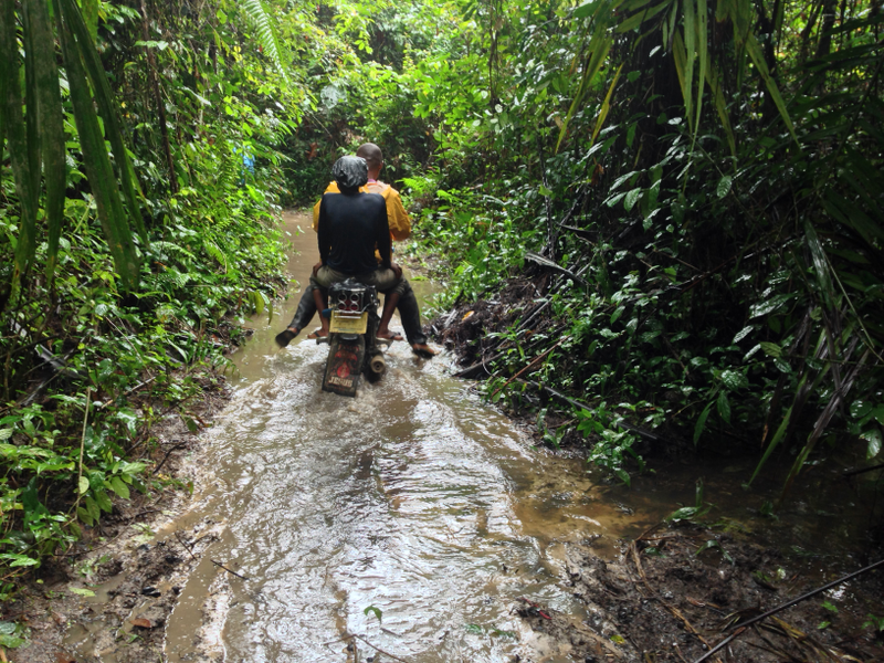 A man and a women ride a motorbike though a polluted area of the Niger Delta.